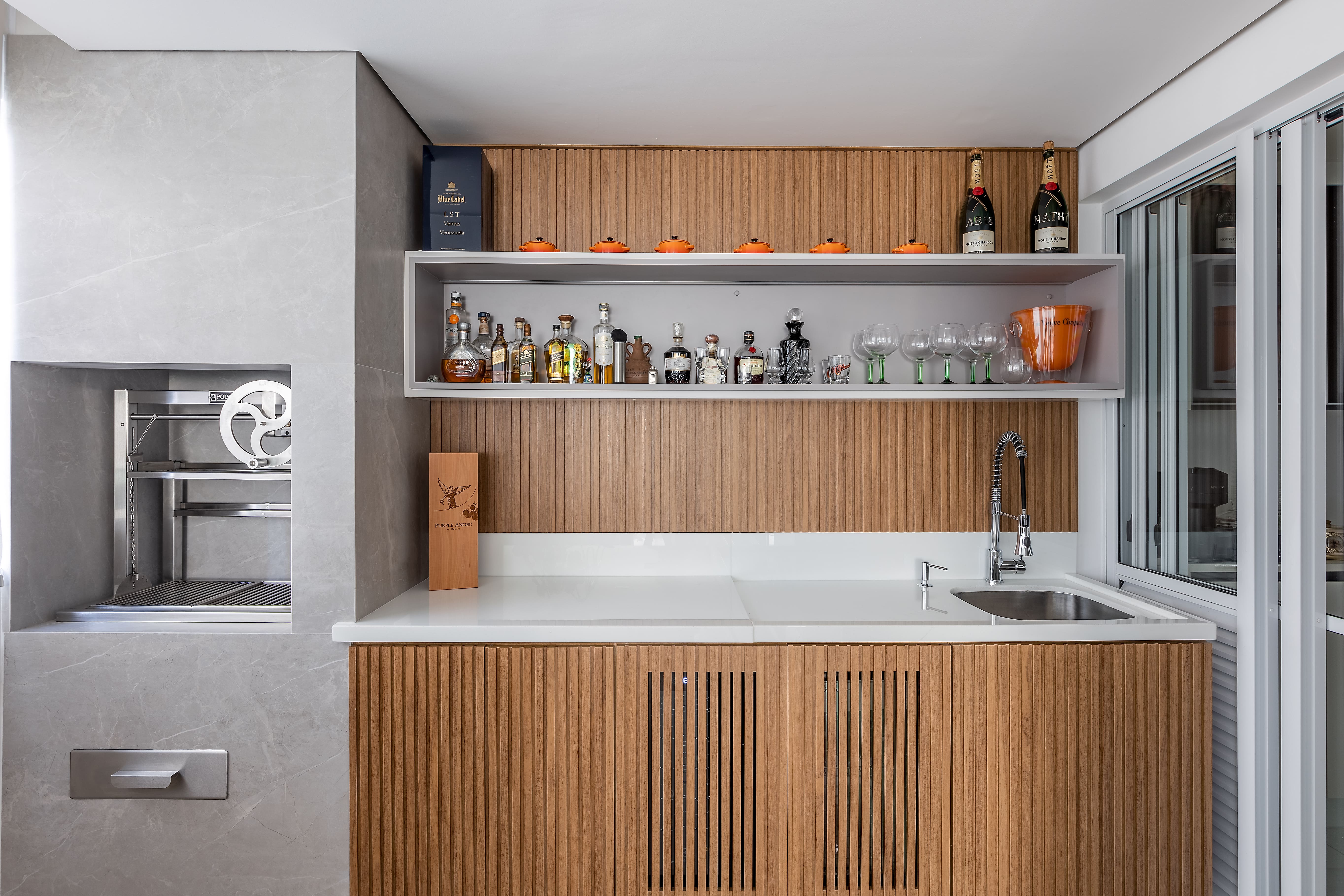 Uma área gourmet completa, com a churrasqueira é revestida com porcelanato.