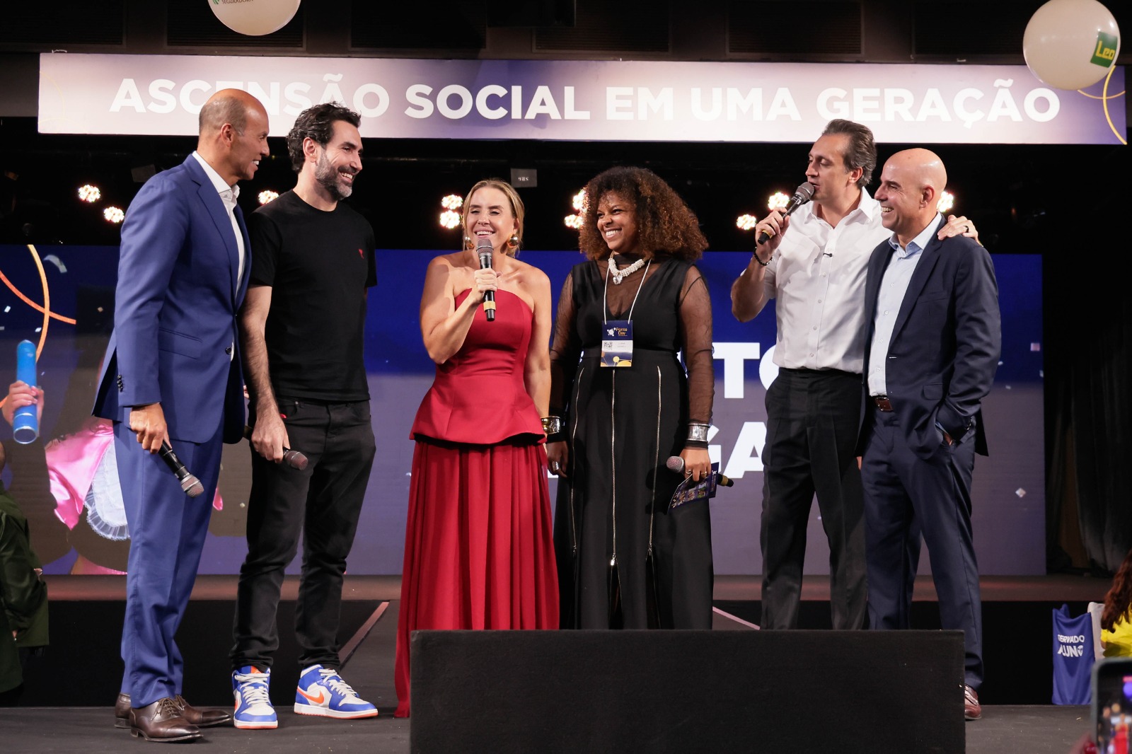 Bartira Almeida (de vermelho), fundadora e presidente do Instituto Ponte, recebe a notícia da doação do iFood no evento Ponte Day, em São Paulo