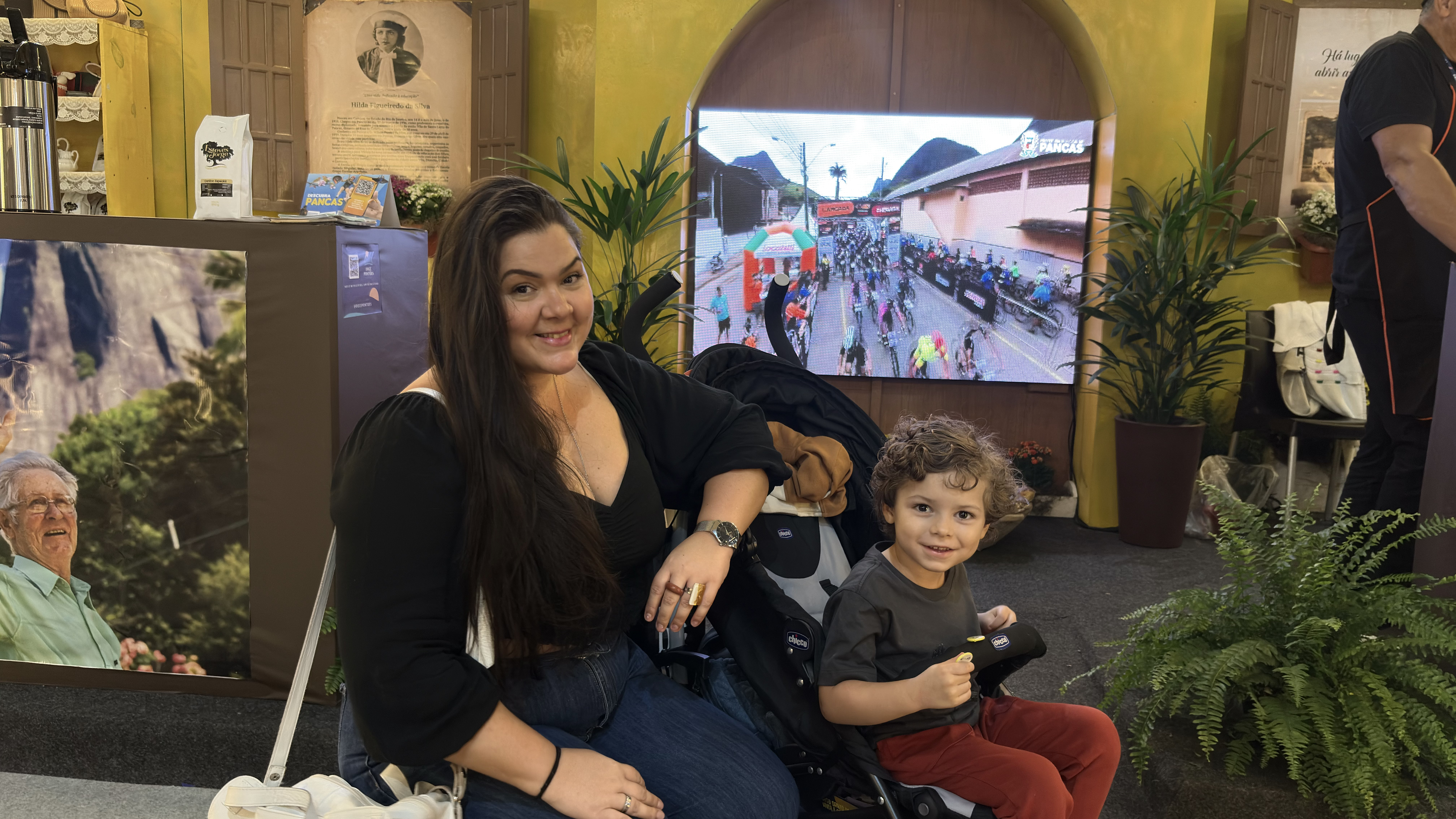 Mariana Muniz visita o estande de Pancas com o filho e relembra memórias da infância ao reencontrar sabores típicos da cidade.