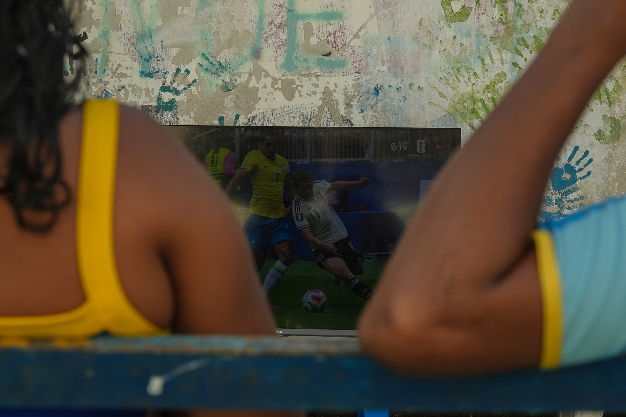 Moradoes do bairro São Jorge, na Grande São Pedro, assistem ao jogo do Brasil contra o Japão