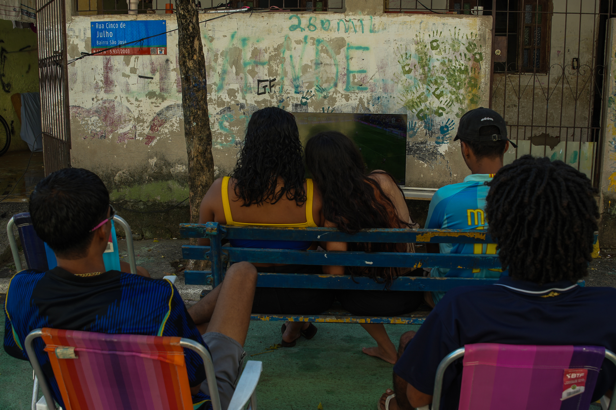 Moradoes do bairro São Jorge, na Grande São Pedro, assistem ao jogo do Brasil contra o Japão