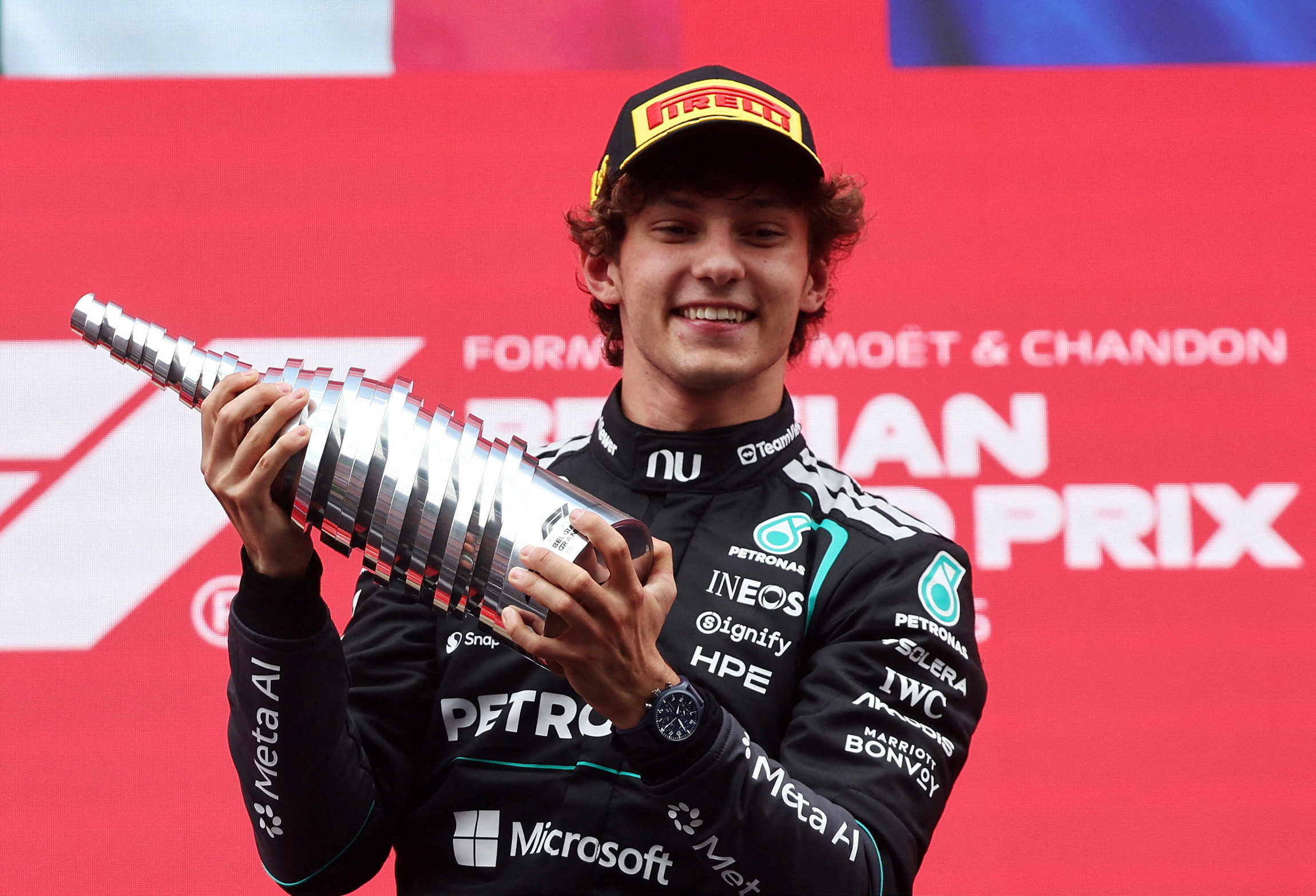 O piloto da Mercedes, Andrea Kimi Antonelli, comemora com um troféu no pódio após vencer o Grande Prêmio da Bélgica