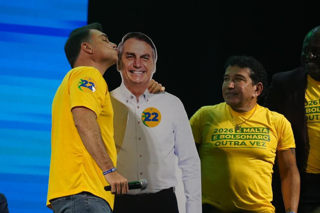 Flávio, ao lado de Magno, beija imagem do pai, Jair Bolsonaro