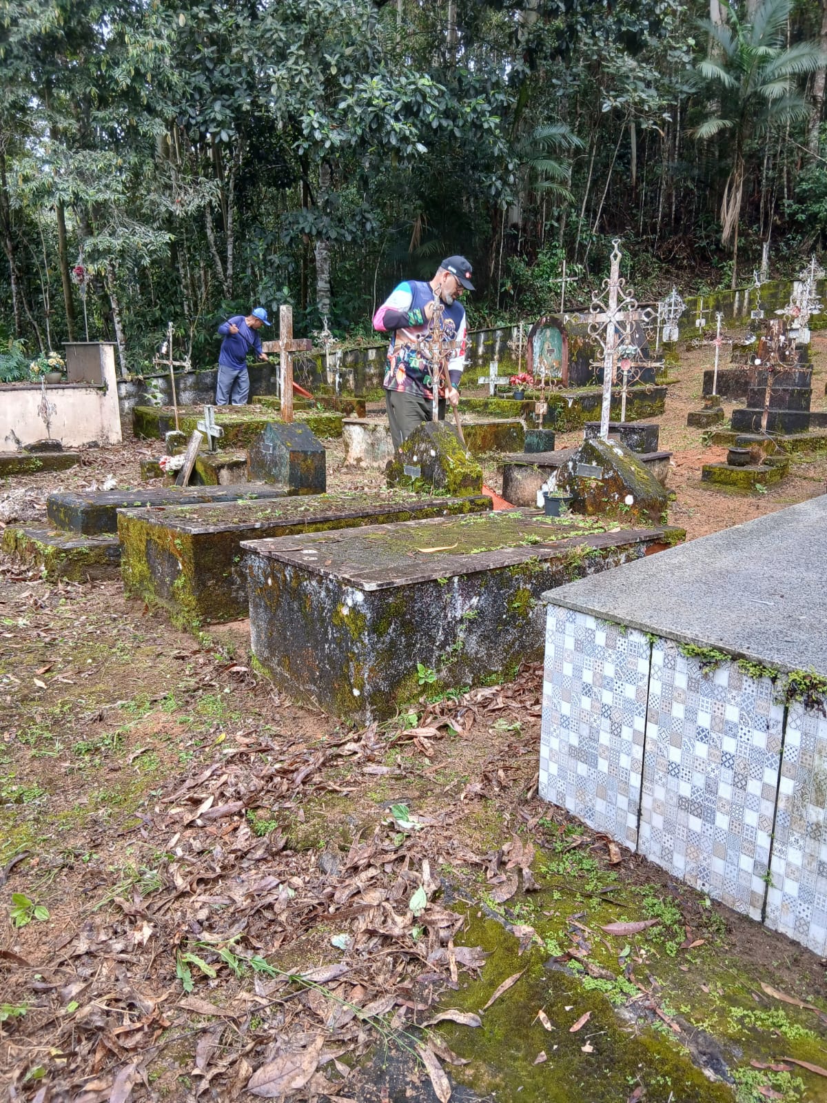 Membros da comunidade limpam o Cemitério de Ribeirão do Cristo para receber os visitantes no Dia de Finados