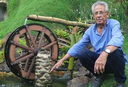 Carolino ao lado da roda d’água na entrada de Campinho, com lago, oratório e paisagismo, idealizada por ele