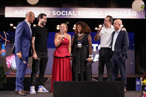 Bartira Almeida (de vermelho), fundadora e presidente do Instituto Ponte, recebe a notícia da doação do iFood no evento Ponte Day, em São Paulo