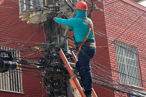 Operário remove cabos e fios inativos de poste em Colatina